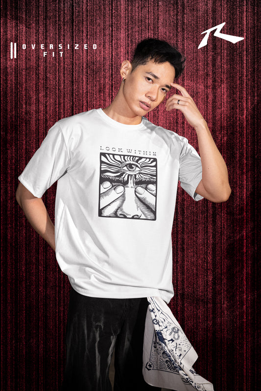 Person wearing a white t-shirt with a graphic design against a red curtain background