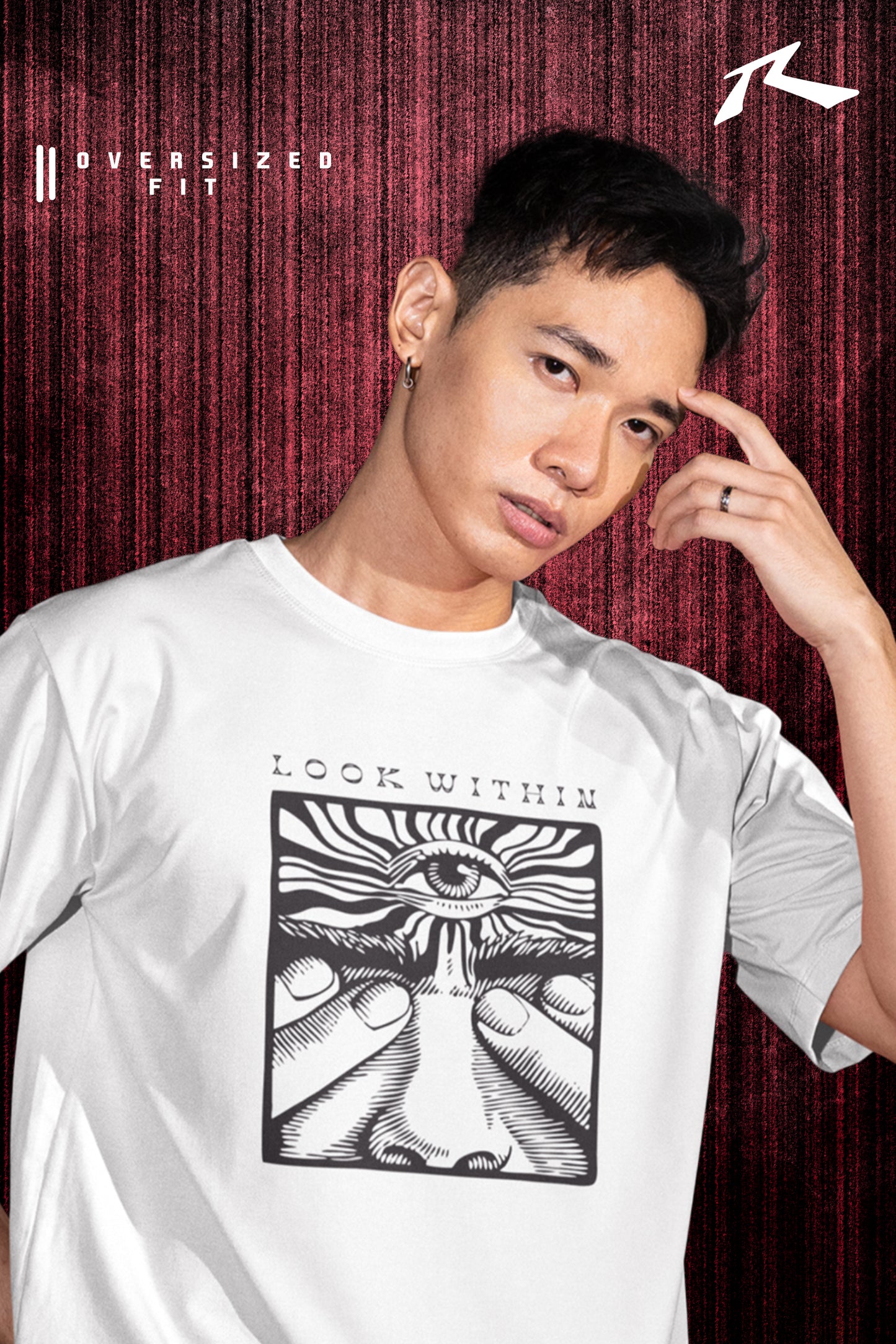 Person wearing a white t-shirt with a graphic design and text, posing against a red curtain background.