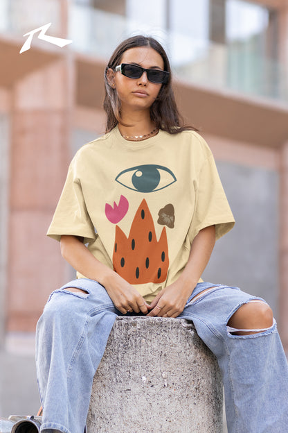 Person wearing a graphic t-shirt and sunglasses, sitting on a concrete block with a blurred background