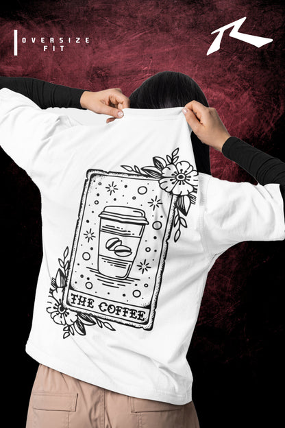 Person holding up a white t-shirt with black graphic design on a dark background